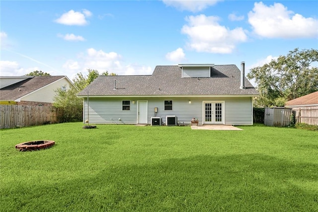 back of property featuring french doors, a lawn, and central AC unit