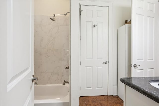 bathroom with tiled shower / bath, vanity, and hardwood / wood-style floors