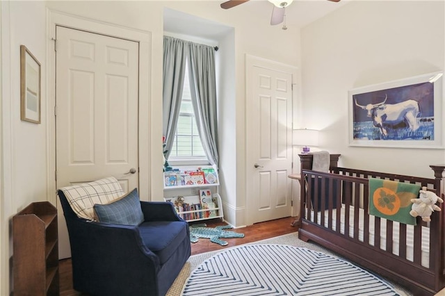 bedroom featuring hardwood / wood-style floors and a crib