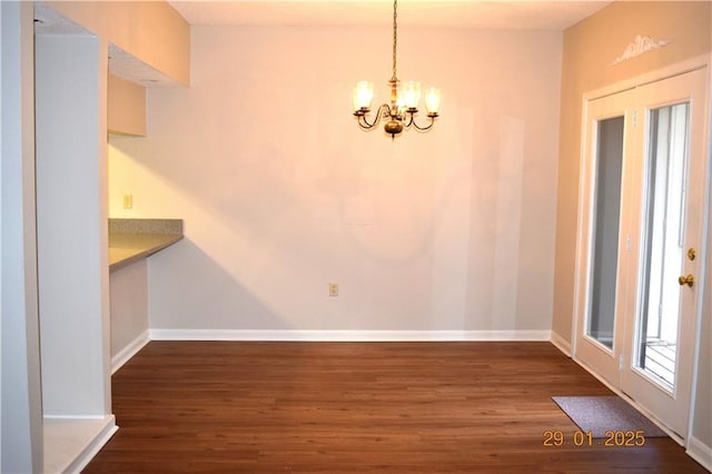 unfurnished dining area with a chandelier and dark wood-type flooring