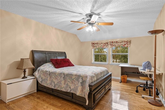 bedroom with ceiling fan, light hardwood / wood-style flooring, and a textured ceiling