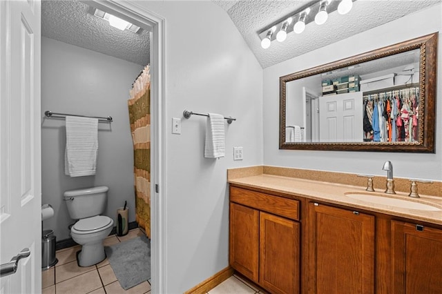 bathroom with toilet, a textured ceiling, vanity, tile patterned flooring, and baseboards