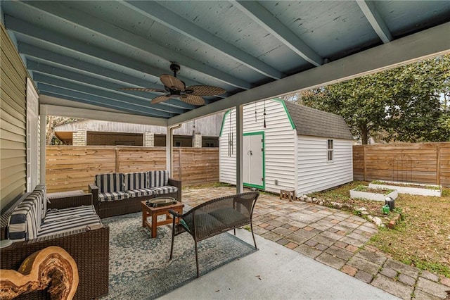 view of patio with ceiling fan, a fenced backyard, an outdoor structure, a shed, and an outdoor living space