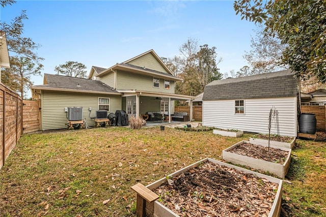 back of property with cooling unit, a storage unit, a patio area, and a lawn