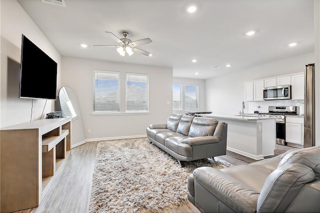 living room with ceiling fan and light hardwood / wood-style floors