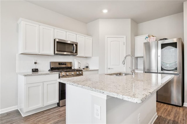 kitchen featuring sink, a center island with sink, appliances with stainless steel finishes, white cabinets, and backsplash