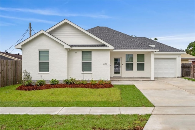 ranch-style home with fence, concrete driveway, a front yard, roof with shingles, and a garage