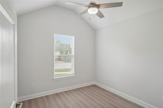 unfurnished room with a ceiling fan, lofted ceiling, wood finished floors, and baseboards