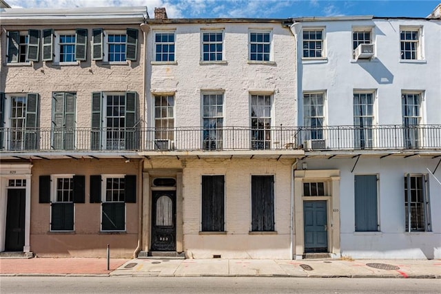 townhome / multi-family property with cooling unit and brick siding