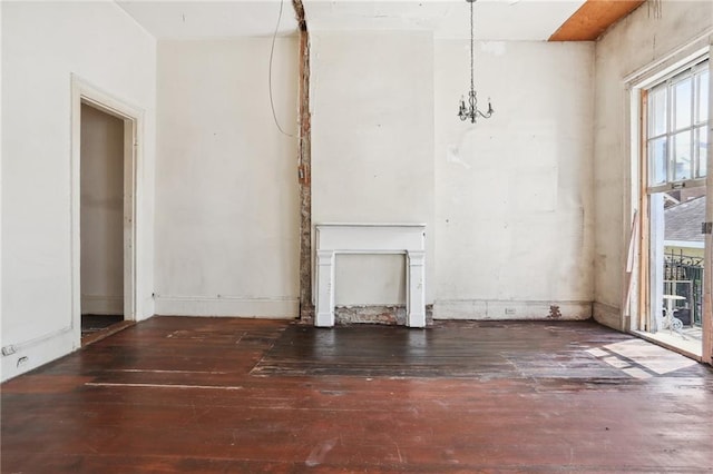 unfurnished living room with a notable chandelier and dark wood-style flooring