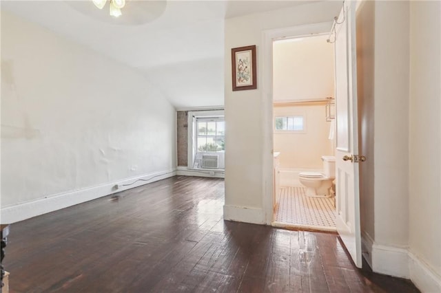 interior space with dark wood-style floors, lofted ceiling, ceiling fan, and baseboards