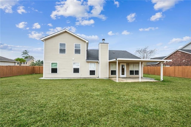 back of house with a patio area, a fenced backyard, a chimney, and a lawn