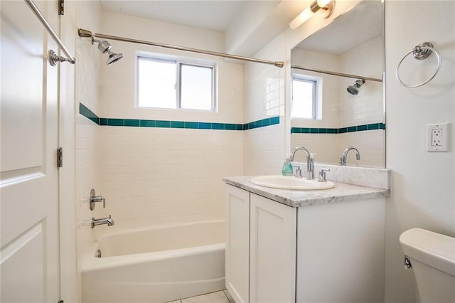 full bathroom featuring tiled shower / bath combo, vanity, and toilet