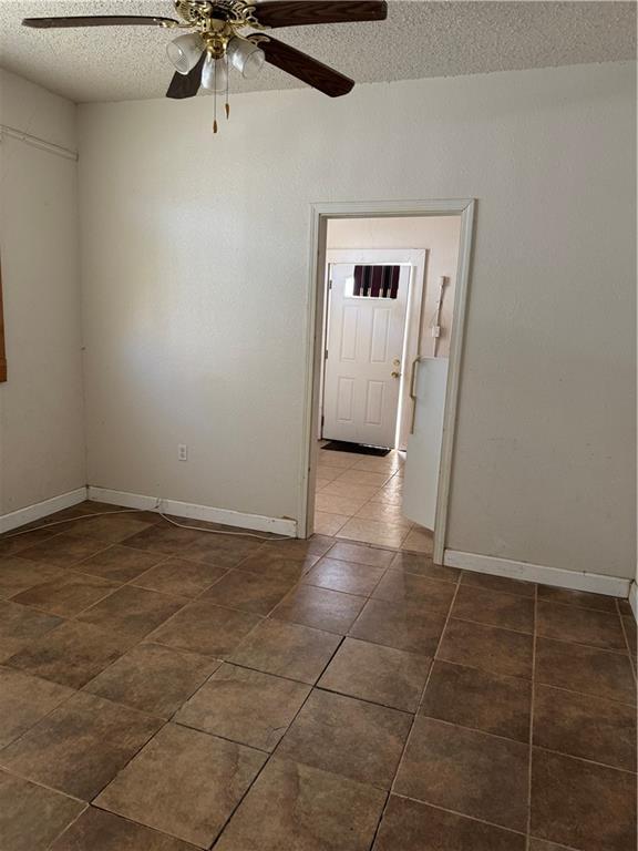 tiled spare room featuring ceiling fan and a textured ceiling