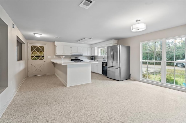 kitchen featuring stainless steel appliances, kitchen peninsula, and white cabinets