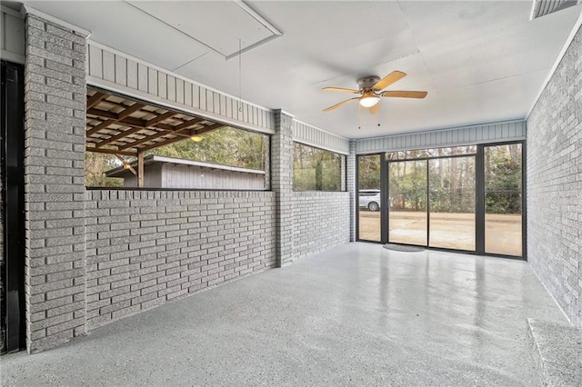 unfurnished sunroom featuring ceiling fan