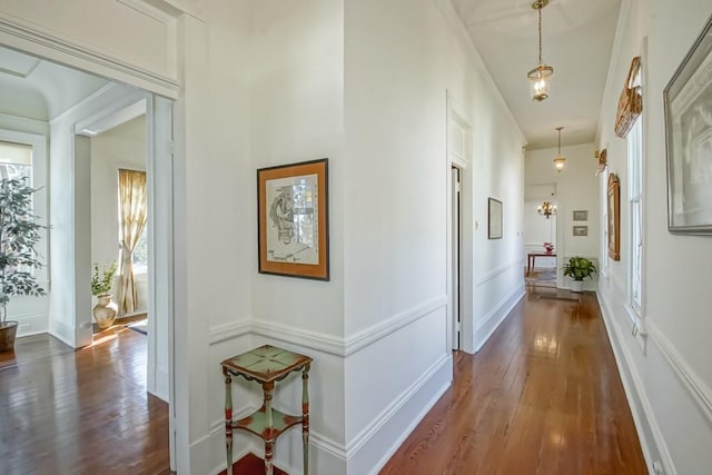 hall with dark hardwood / wood-style flooring and a chandelier