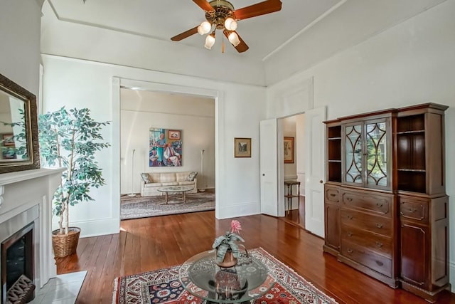 living room featuring ceiling fan and dark hardwood / wood-style floors