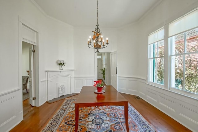 dining area with hardwood / wood-style flooring and an inviting chandelier