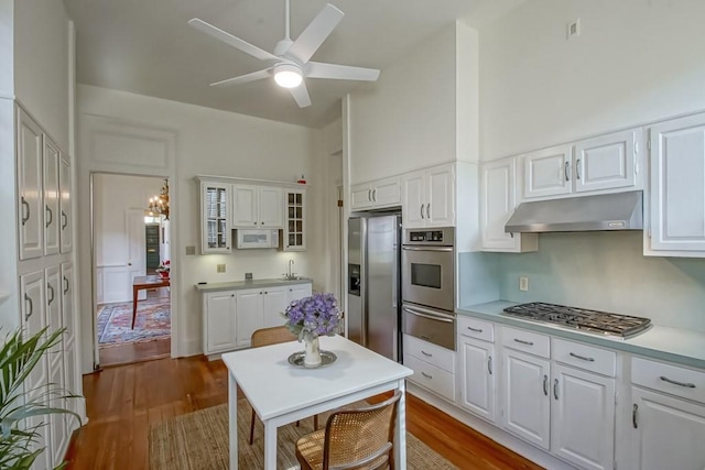 kitchen with hardwood / wood-style flooring, stainless steel appliances, and white cabinets