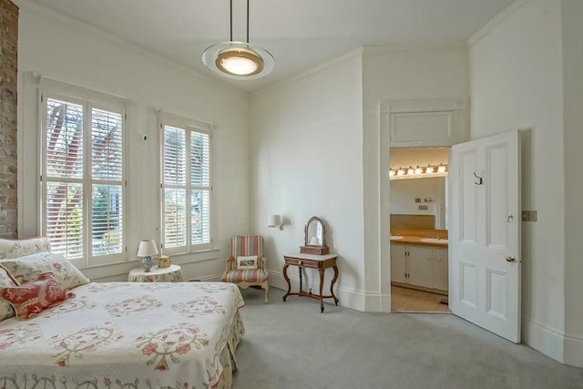 bedroom featuring crown molding, ensuite bathroom, and light carpet