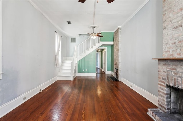 unfurnished living room with dark hardwood / wood-style flooring, a brick fireplace, ornamental molding, and ceiling fan