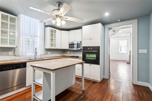 kitchen featuring a kitchen island, white cabinetry, sink, a breakfast bar area, and stainless steel appliances