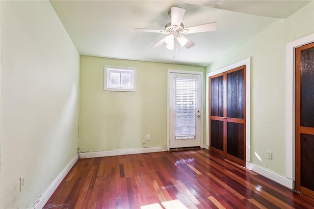 empty room with dark hardwood / wood-style flooring and ceiling fan