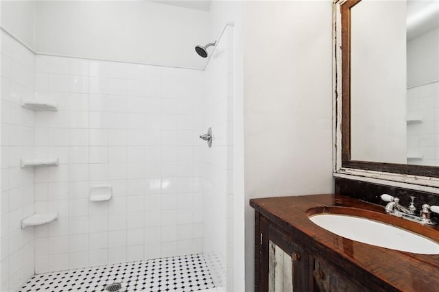 bathroom with vanity and a tile shower