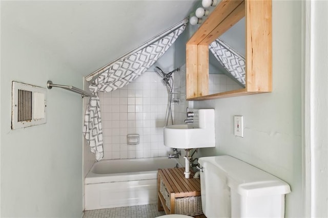 bathroom with tile patterned floors, toilet, and tiled shower / bath