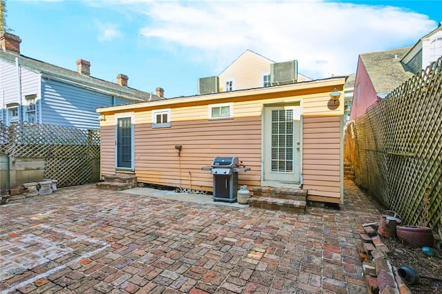 rear view of house with central AC and a patio