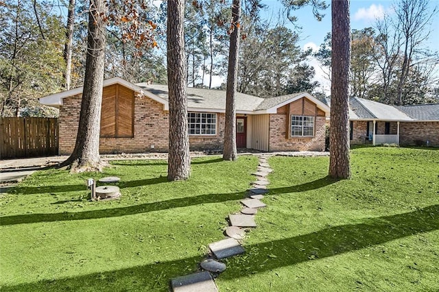 ranch-style home with brick siding, a front yard, and fence