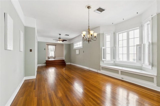 interior space featuring dark wood-type flooring and ceiling fan with notable chandelier