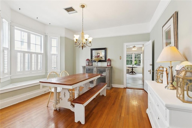 dining room with hardwood / wood-style flooring and a chandelier