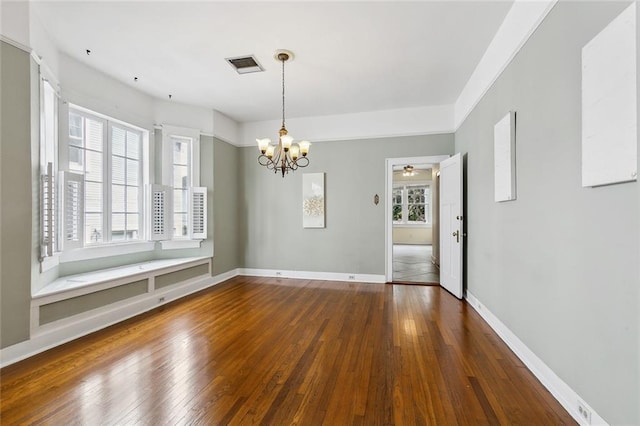 unfurnished dining area featuring dark wood-type flooring and a chandelier