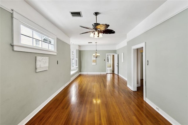 unfurnished room featuring ceiling fan with notable chandelier and dark hardwood / wood-style flooring