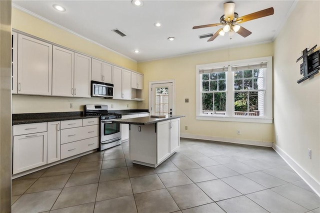 kitchen with crown molding, white cabinetry, stainless steel appliances, a kitchen breakfast bar, and a kitchen island