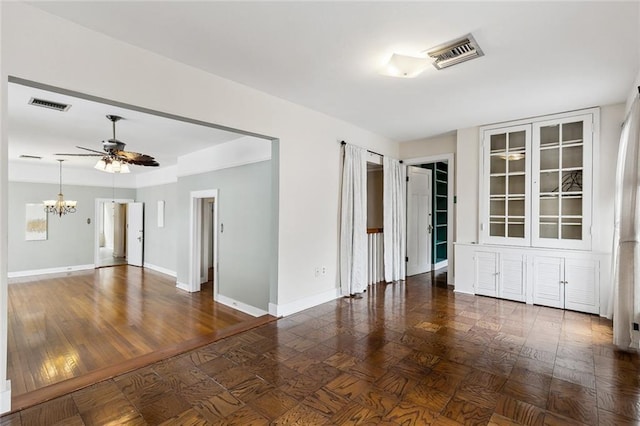 unfurnished room with ceiling fan with notable chandelier and dark wood-type flooring