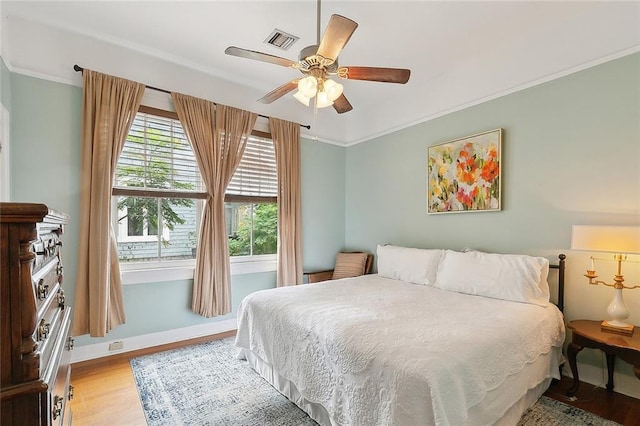 bedroom with crown molding, ceiling fan, and light hardwood / wood-style flooring