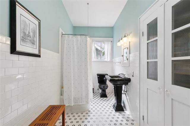 bathroom featuring sink and tile walls