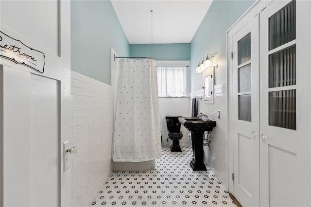 bathroom featuring tile walls and a shower with curtain