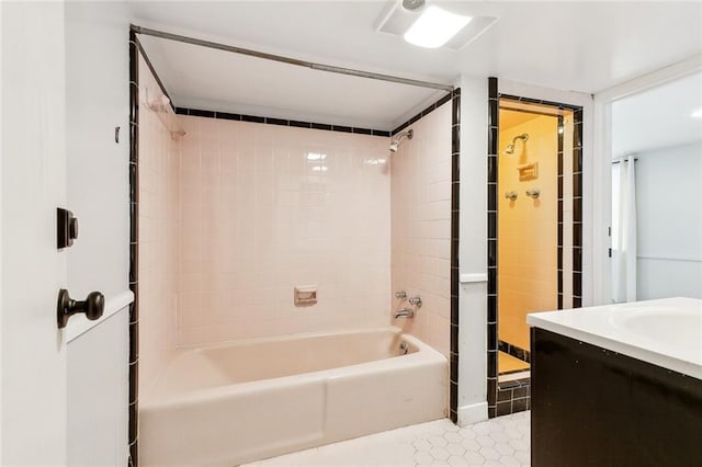 bathroom with tile patterned flooring, vanity, and tiled shower / bath