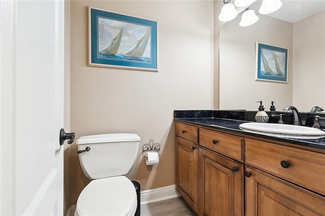 bathroom featuring vanity, toilet, and hardwood / wood-style floors