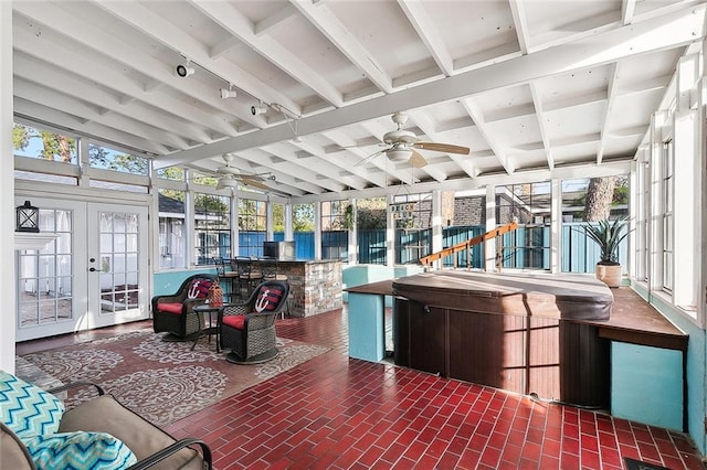 sunroom / solarium with vaulted ceiling with beams, plenty of natural light, french doors, and ceiling fan