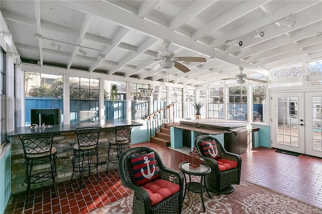 sunroom / solarium with french doors, track lighting, ceiling fan, and beamed ceiling