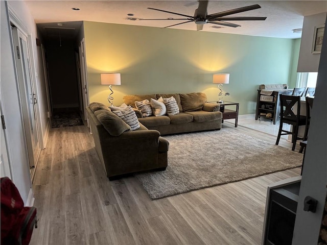 living room with wood-type flooring and ceiling fan