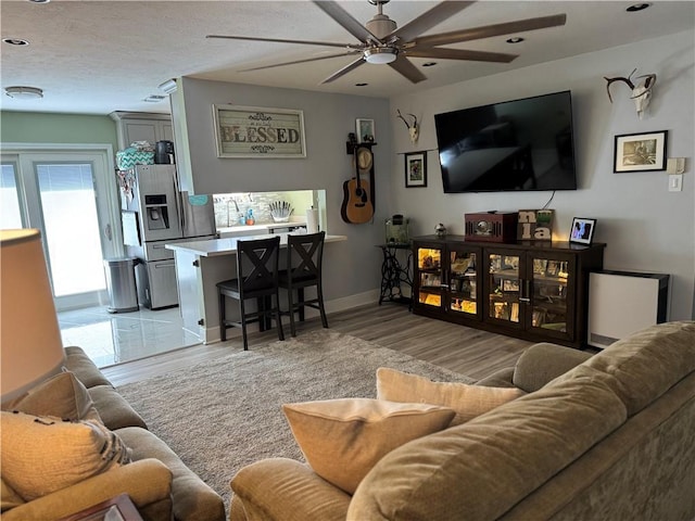 living room featuring light hardwood / wood-style flooring and ceiling fan