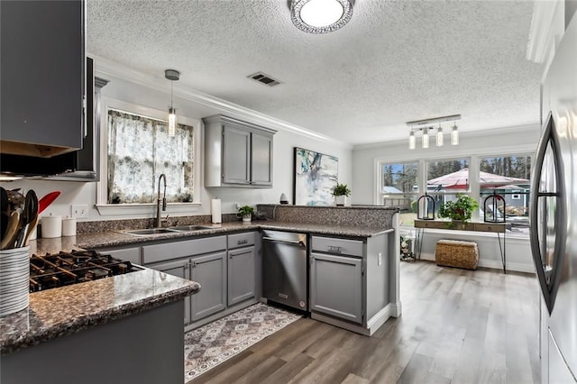 kitchen with gray cabinets, dark hardwood / wood-style floors, decorative light fixtures, sink, and kitchen peninsula