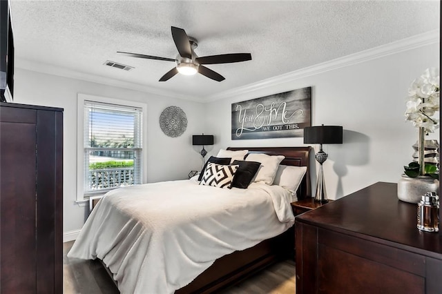 bedroom with crown molding, wood-type flooring, and a textured ceiling