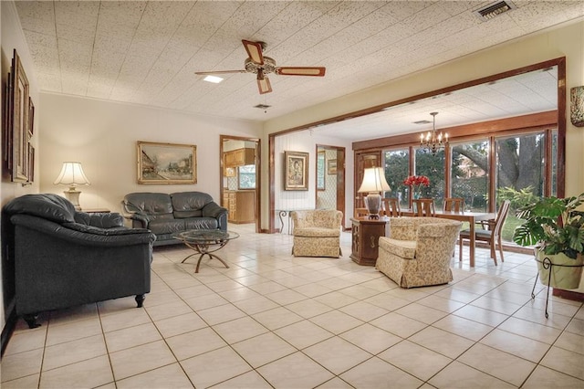 living room with ceiling fan with notable chandelier and light tile patterned floors